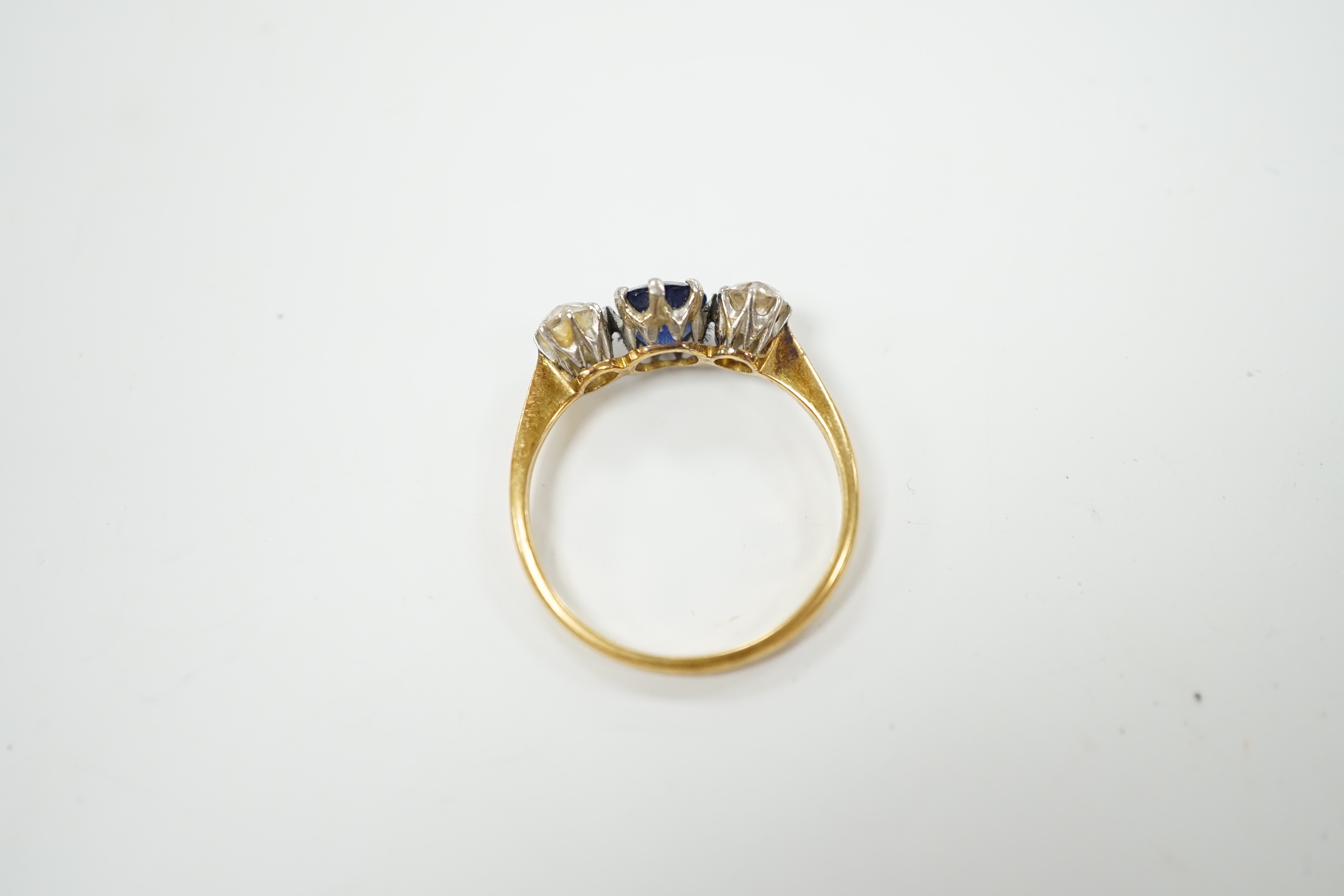 A yellow metal, single stone sapphire and two stone diamond set ring, size N/O, gross weight 2.2 grams.